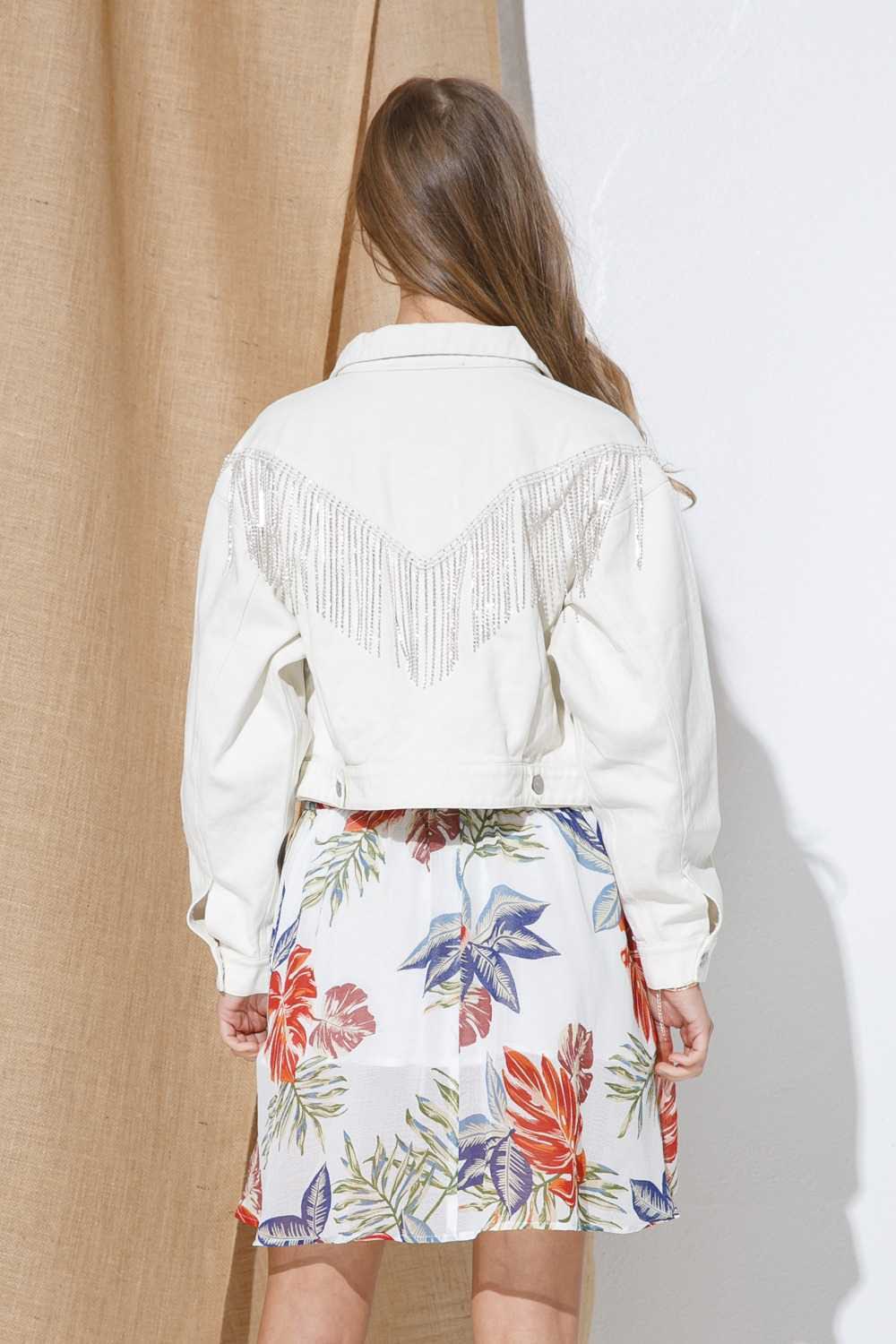 Elevate your style with our Denim Chevron Rhinestone Fringe Jacket. Made with 100% cotton, this white denim piece exudes boho-chic vibes with its rhinestone fringe accents. Perfect for any occasion, this jacket combines western fashion with bohemian and urban elements. Essential for your wardrobe, this women's jacket is a must-have for any cowgirl, fashionista, or trendsetter.