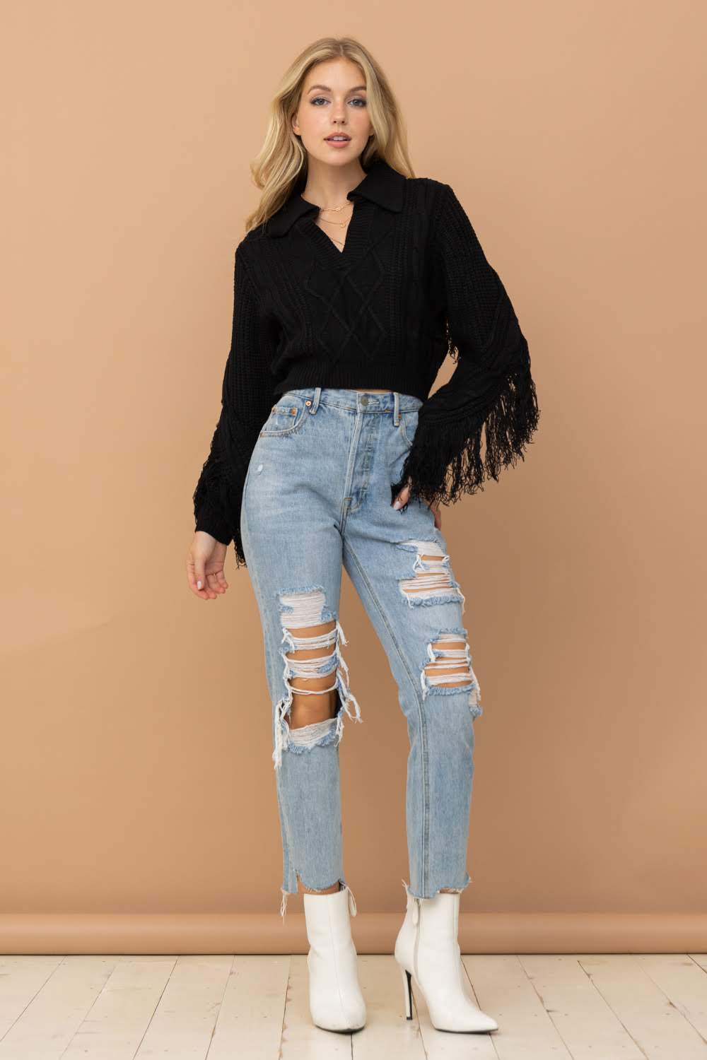 Elevate your wardrobe with the Crop Collared Fringe Sleeve Western Sweater by Blue B. Featuring a chic urban western, boho-cowgirl style, this sweater is perfect for adding a touch of boho-chic to any outfit. With its fringe detail, it adds a trendy and stylish element. Upgrade your look with this must-have sweater.