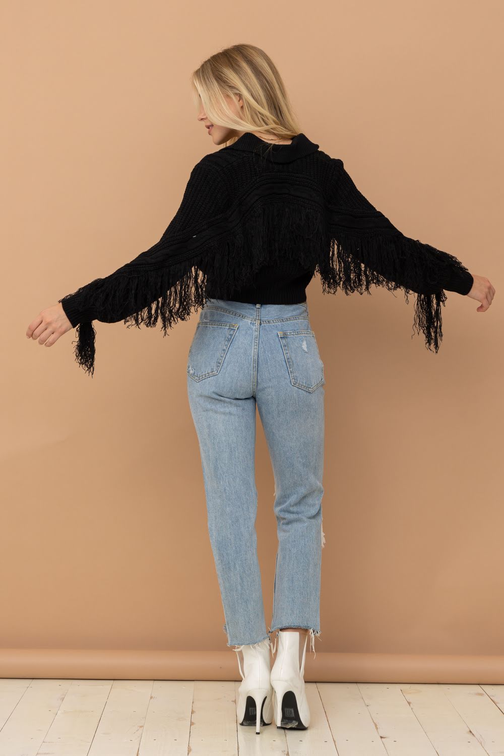 Elevate your wardrobe with the Crop Collared Fringe Sleeve Western Sweater by Blue B. Featuring a chic urban western, boho-cowgirl style, this sweater is perfect for adding a touch of boho-chic to any outfit. With its fringe detail, it adds a trendy and stylish element. Upgrade your look with this must-have sweater.