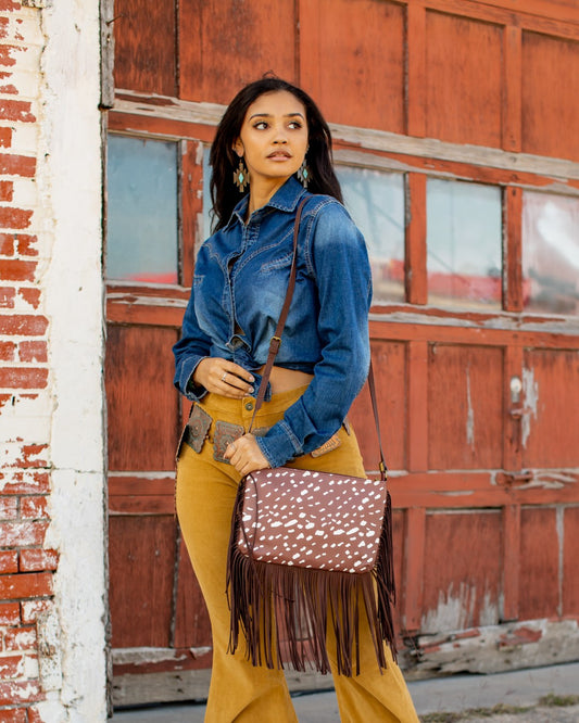 This Western gipsy crossbody bag showcases a unique and stylish deer animal print, perfect for adding a touch of personality to any outfit. And with its fringe shoulder design, it offers both fashion and function for on-the-go convenience. Elevate your style with this statement bag.