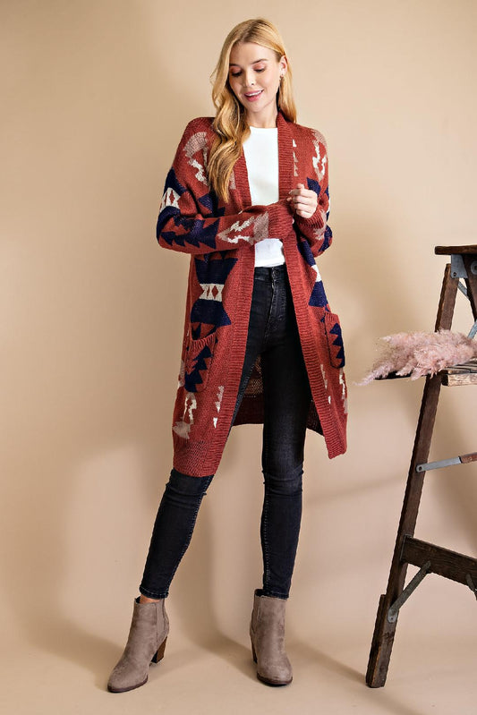 Expertly crafted with 100% rayon fabric, this Aztec print open-front cardigan in brick red is a must-have for your wardrobe.  Its long mid-thigh length and side pockets provide both style and functionality, making it perfect for any occasion.  Buttonless design with a touch of western flair.