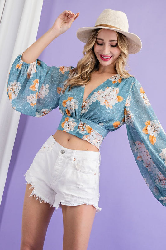 Elevate your wardrobe with our Flower Print Surplice Top! Made with a soft and flowy fabric, this blouse features a surplice neckline and adjustable tie for a flattering fit. Embrace the ultimate boho-chic style with this cropped long-sleeve top. Perfect for any occasion, this top will make you feel confident and stylish.