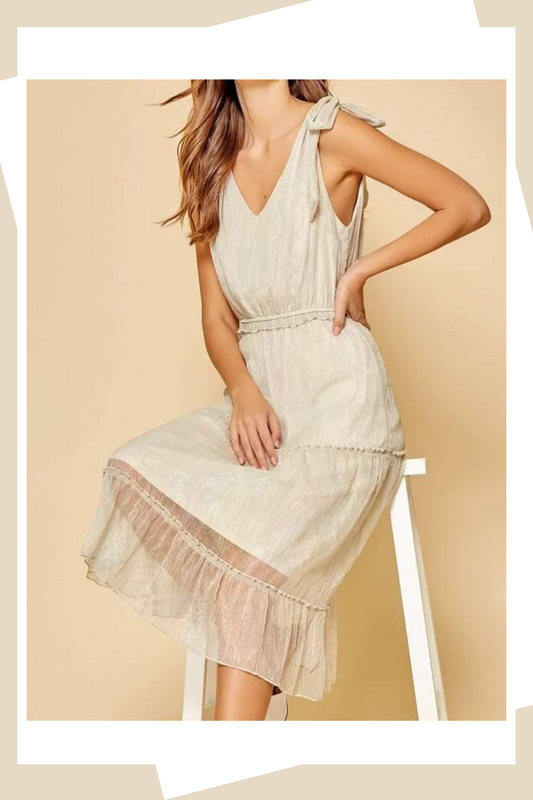 Elevate your style with our Emmy Sea Shell Shimmery Midi Dress. Featuring a sleeveless bodice, shoulder tie straps, and an elastic waistband, this dress is both chic and comfortable. With its boho-chic, urban western style, this dress is perfect for any occasion. Add a touch of romance to your wardrobe with this essential piece.